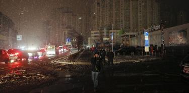 Personas caminan por las calles oscuras de Kiev, este viernes 16 de diciembre de 2022, tras la nueva ronda de bombardeos rusos contra la infraestructura civil ucraniana.