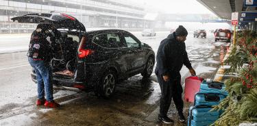 Pasajeros llegan al aeropuerto de Chicago, Illinois, este jueves 22 de diciembre de 2022, en medio del inicio de una tormenta invernal que amenaza a medio Estados Unidos.
