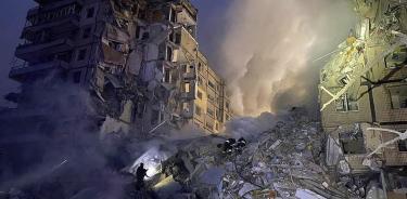 Rescatistas ucranianos trabajan en el sitio de un edificio residencial alcanzado por bombardeos en Dnipro.