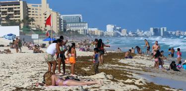 Turistas permanecen en una playa invadida por sargazo, el 13 de febrero de 2023, en Playa del Carmen.