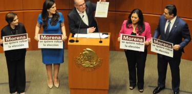 Senadores del PAN participan en la discusión en torno al plan b utilizando cartulinas en alusión a Morena.