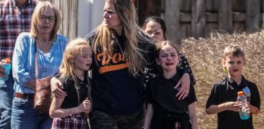 Una mujer consuela a dos niñas fuera de la escuela atacada en Nashville, Tennessee, traumatizadas por la experiencia vivida