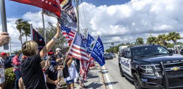 Seguidores saludan a Trump en Palm Beach al paso de la caravana del expresidente camino del aeropuerto para tomar su avión privado que lo trasladará a Nueva York