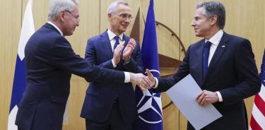 El canciller de Finlandia, Pekka Haavisto, estrecha la mano al secretario de Estado de EU, Antony Blinken, en presencia del secretario general de la OTAN, Jens Stoltemberg, este martes en Bruselas