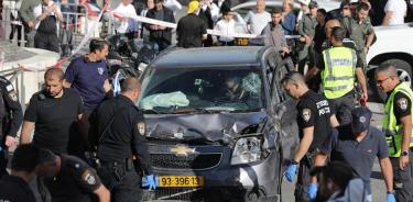 La policía israelí junto al coche usado por el palestino para atropellar a la gente en el mercado de Jerusalén Oeste