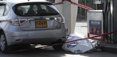 El cuerpo de una de las víctimas israelíes en la gasolinera en el asentamiento judío de Eli, en la Ciosjordania ocupada, donde ocurrió el ataque palestino