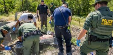 Agentes de la patrulla fronteriza levantan rescatan cuerpos de migrantes ahogados en el Río Bravo