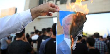 Un manifestante iraquí quema la imagen del rey sueco en una protesta en la plaza Tahrir, en Bagdad