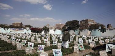 Un yemení camina entre retratos de las tumbas de los que murieron en el prolongado conflicto