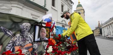 Un hombre lleva flores a un altar improvisado en memoria de Prigozhin, líder de los Wagner