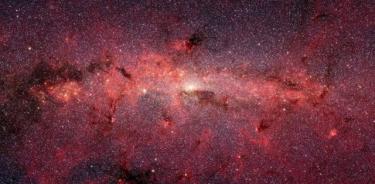 El centro de la Vía Láctea en luz infrarroja, visto por el Telescopio Espacial Spitzer. Un estudio reciente muestra menos tipos de planetas más comunes en las afueras de nuestra galaxia.