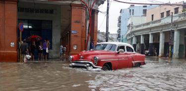 Un coche se desplaza este martes por una calle inundada de La Habana Vieja, tras el paso de Idalia