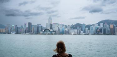 Una mujer observa el perfil urbano de Hong Kong antes del la llegada del súpertifón 'Saola' este viernes