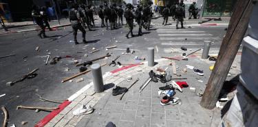 TAgentes de policía israelíes pasan junto a porras y zapatos abandonados en el suelo después de los enfrentamientos en Tel Aviv