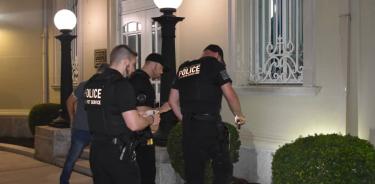 Policías estadounidenses revisan los daños leves causados por el lanzamiento de dos cocteles molotov en la facahada de la embajada de Cuba en Washington