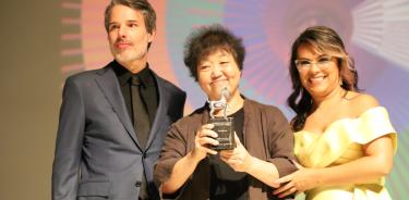 La cineasta Yim Soon-rye posa con su premio junto a la directora del festival y otro miembro de la organización.