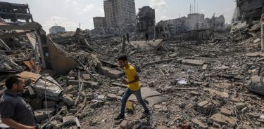 Palestinos caminan entre los escombros tras un ataque a la zona de Al-Ramal, tras un ataque israelí