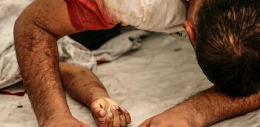 Un palestino llora ante el cadáver de su sobrino, alcanzado por fuego israelí en Gaza