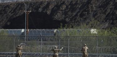 Miembros de la Guardia Nacional de Texas instalan barricadas de alambre de navajas, hoy, en el muro fronterizo en Ciudad Juárez, en Chihuahua.