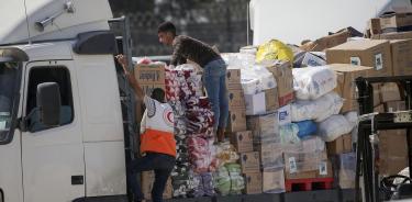 Personal de la Media Luna Roja descarga la ayuda humanitaria de un camión en Gaza