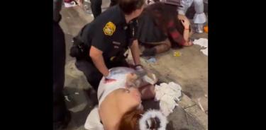 Un agente atiende a una joven herida durante la fiesta de Halloween en Tampa, Florida