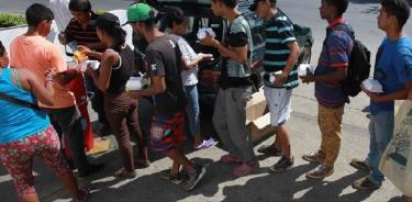 Venezolanos reciben comida afuera de la terminal de transportes en Cali, Colombia