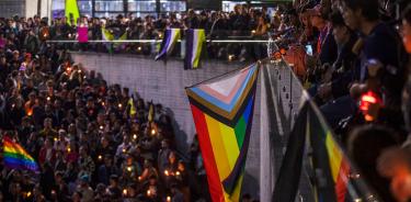 Miembros de la comunidad LGBT+ protestan con mantas y veladoras para exigir justicia por el asesinato de le magistrade Ociel Baena