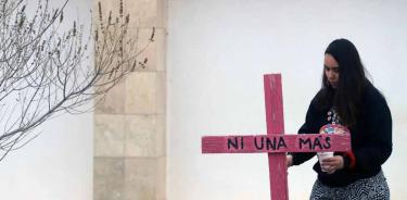 Activista en una pinta de cruces y pega de pesquisas en el Memorial Campo Algodonero, en Ciudad Juárez