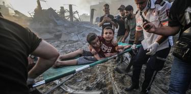 Niños rescatados de los escombros de una zona destruida por bombardeos israelíes.