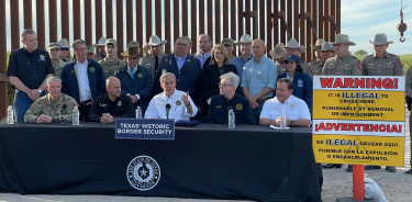 El gobernador de Texas, Greg Abbott, durante la firma el lunes de la ley antiinmigrante más dura de EU, realizada frente a un tramo del muro fronterizo en Brownsville