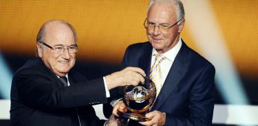 Una fotografía de archivo de la ex leyenda del fútbol alemán Franz Beckenbauer (dcha.) posando con el trofeo tras recibir el Premio Presidencial de la FIFA de manos del presidente de la FIFA, Joseph S. Blatter
