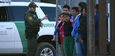 Agente de la patrulla fronteriza estadounidense habla a un grupo de jóvenes migrantes centroamericanos tras ser detenidos en los márgenes del Rio Bravo, a la altura de Ciudad Juárez