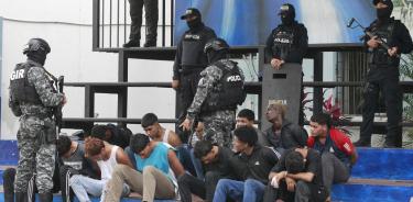 Policías custodian hoy a los detenidos de un grupo armado por la toma temporal de un canal de televisión ayer, en Guayaquil