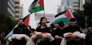 En Brasil, mujeres sostienen muñecos que simbolizan niños asesinados durante una manifestación contra la ofensiva israelí en Gaza