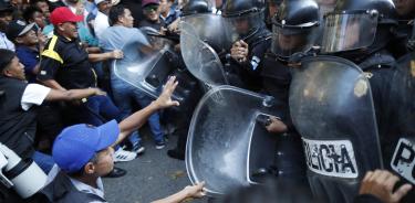 Manifestantes chocan con policías en las afueras del Congreso hoy, en Ciudad de Guatemala