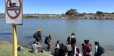Inmigrantes se preparan para cruzar a nado el río Bravo a la altura de Piedras Negras, Coahuila; y del lado texano Eagle Pass