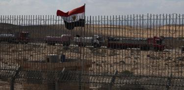 Camiones en el lado egipcio mientras manifestantes israelíes intentan bloquear la puerta en el cruce fronterizo de Nitzana entre Israel y Egipto