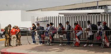 Migrantes e fila para solicitar asilo en EU en el puerto fronterizo del Chaparral en Baja California