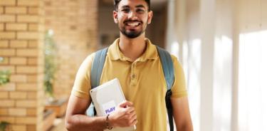 Face portrait, student and man in university ready for back to school learning, goals or targets. Scholarship, education and happy, confident and proud male from India holding tablet for studying.
