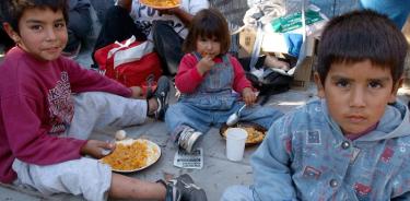 Niños de barrios pobres en la periferia de Buenos Aires, reciben alimentos por parte de instituciones solidarias que se instalan en la vías públicas