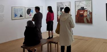 Varios visitantes observan pinturas de Françoise Gilot en el Museo Picasso de París.