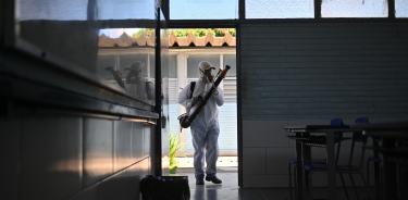 Un trabajador fumiga un salón de clases en una escuela para prevenir la proliferación del mosquito transmisor del dengue Aedes aegypti, el 16 de marzo de 2024, en la región administrativa de Ceilândia, en Brasilia