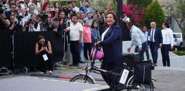 Llega Xóchitl Gálvez al debate en bicicleta