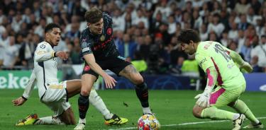 El guardameta alemán del Manchester City, Stefan Ortega (d), intenta detener el remate del centrocampista del Real Madrid, Jude Bellingham.