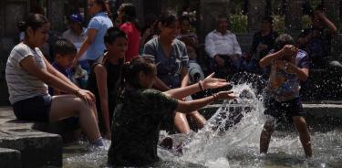 Una familia mitiga el calor en las fuentes de Alameda Central, en la Ciudad de México/CUARTOSCURO/