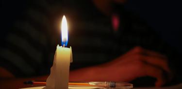 Un estudiante lee un texto a la luz de una vela este miércoles en Quito