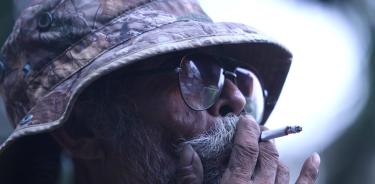 Un hombre de edad avanzada fuma despreocupado