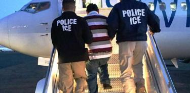 Agentes de inmigración estadounidenses suben a un avión a un inmigrante deportado