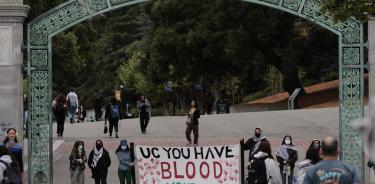 Manifestantes propalestinos en la entrada de la Universidad de California-Berkeley, con un cartel dirigido a las autoridades: “Tienen las manos manchadas de sangre”