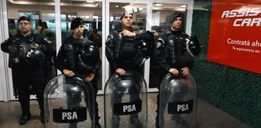 Integrantes de fuerzas de seguridad vigilan durante unas protestas este lunes en el Aeroparque Jorge Newbery en Buenos Aires